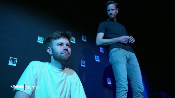 Zwei Männer stehen auf einer Bühne. © Screenshot 