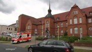 Ein Rettungswagen verlässt die Zufahrt zu einem kleineren Krankenhaus. © Screenshot 