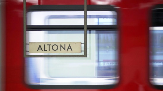 Ein Schild auf dem "Altona" steht und eine S-Bahn im Hintergrund © Screenshot 