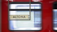 Ein Schild auf dem "Altona" steht und eine S-Bahn im Hintergrund © Screenshot 