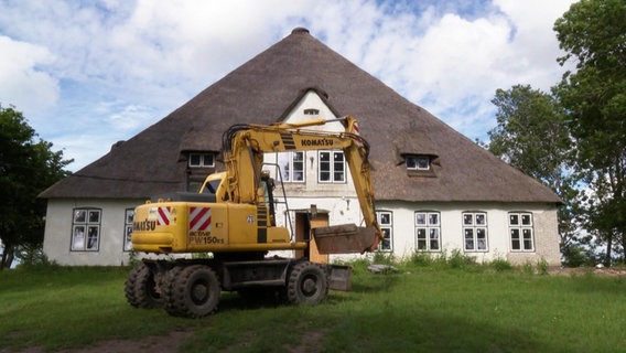 Ein Bagger steht vor einem alten Bauernhaus. © Screenshot 