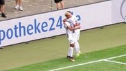 Stürmer Elias Saad wird von einem Mitspieler auf dem Platz umarmt. © Screenshot 