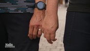 Zwei Männer beim Hände halten, sie tragen Eheringe. © Screenshot 