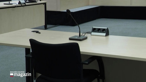 Tisch mit Mikrophon im Landgericht. © Screenshot 