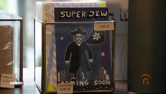 Auf einer Postkarte im Mio Gio Laden in Hamburg steht über und unter einer Illustration eines gläubigen Juden "Super Jew coming soon". © Screenshot 