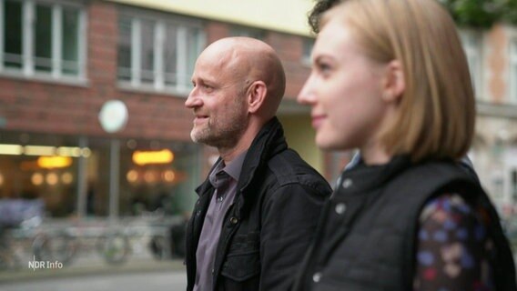 Scharf im Profil zu sehen Schauspieler Jürgen Vogel, unscharf im Vordergrund eine Kollegin. © Screenshot 