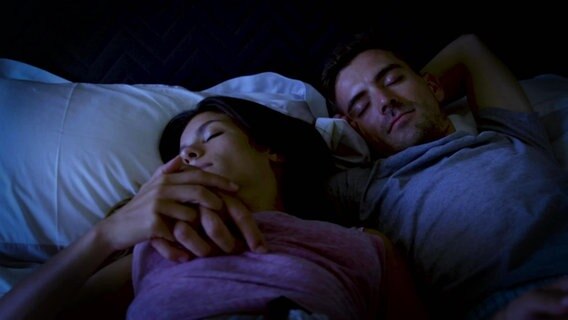 Eine Frau und ein Mann liegen schlafend in einem Bett. © Screenshot 