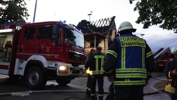 Feuerwehrleute stehen vor einem ausgebrannten Haus. © Screenshot 
