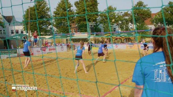 Volleyballspielerinnen und -spieler im Sand. © Screenshot 