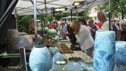 Situation auf dem Töpfermarkt: Kundschaft an einem Stand. © Screenshot 