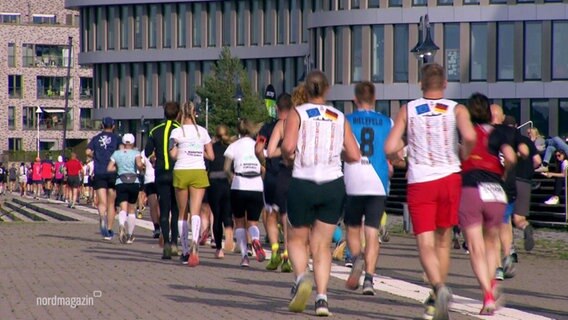 Eine joggende Menschenmenge von hinten. © Screenshot 