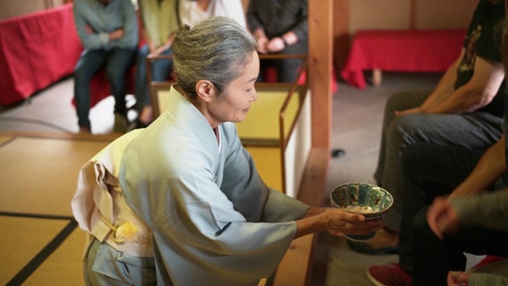 Eine Japanerin in traditioneller Kleidung bei einer Teezeremonie. © Screenshot 