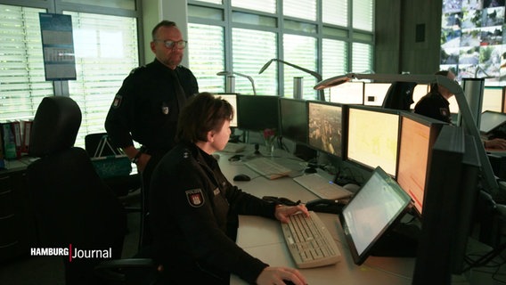 Blick in die Verkehrsleitzentrale: Ein Polizist und eine Polizistin überprüfen verschiedene Monitore. © Screenshot 