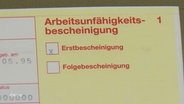 Eine Krankschreibung liegt auf einem Tisch. © Screenshot 