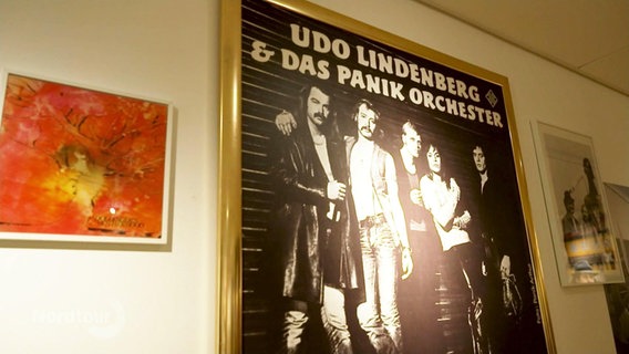 Ein Plakat vom Panikorchester wird in einer Ausstellung zu Udo Lindenberg präsentiert. © Screenshot 