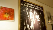 Ein Plakat vom Panikorchester wird in einer Ausstellung zu Udo Lindenberg präsentiert. © Screenshot 