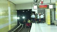 Feuerwehr- und Rettungskräfte versorgen einen Mann in einem Gleisbett. © TNN 