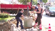 Bauarbeiter versenken einen Betonpoller in der Hamburger Waitzstraße. © Screenshot 