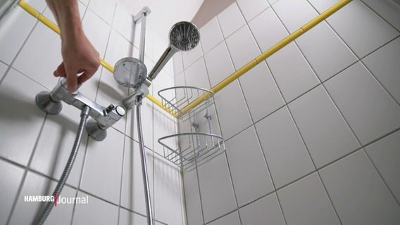 Eine Hand am Wassermischer in der Dusche © Screenshot 