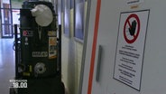 Ein Schild warnt im Hölty-Gymnasium vor Asbestfeinstaub. © Screenshot 