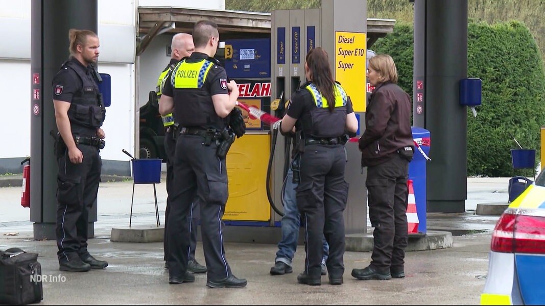 Polizeibeamtinnen an einer Zapfsäule.