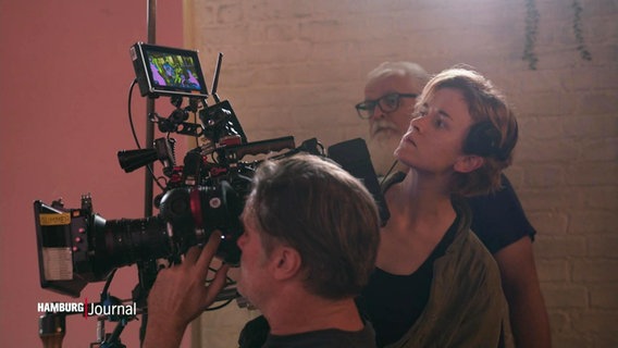 Einer Frau blickt über die Schulter eines Kameramanns in einen Monitor. © Screenshot 