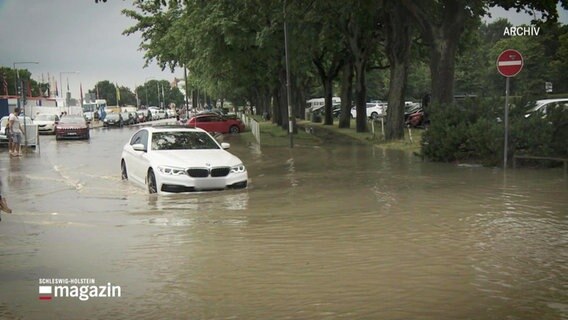 Ein Auto steht wegen einer Überflutung unter Wasser. © Screenshot 