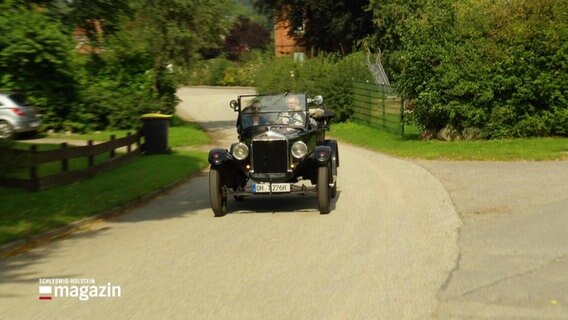 Ein schwarzer Oldtimer fährt auf einer straße in Gömnitz. © Screenshot 