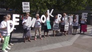 Ältere Damen halten die Buchstaben des Wortes "Demokratie" hoch, dazu ein Schilder mit der Aufschrift "OMAS GEGEN RECHTS". © Screenshot 