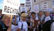 Mehrere ältere Damen protestieren gegen Rechtspopulisten, eine spielt ein Akkordeon. © Screenshot 