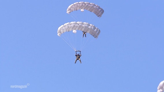 Fallschirmjäger der Bundeswehr gleiten per Fallschirm durch den Himmel. © Screenshot 