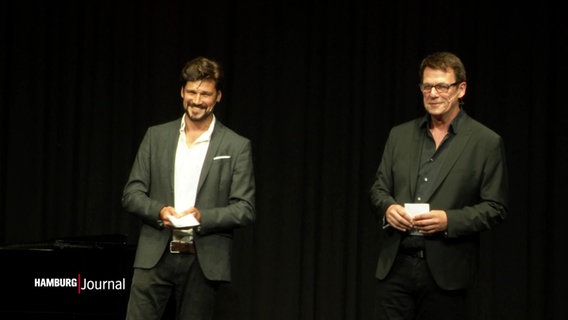Jan-Peter Petersen und Sohn Max Beier stehen auf einer Bühne. © Screenshot 