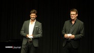 Jan-Peter Petersen und Sohn Max Beier stehen auf einer Bühne. © Screenshot 