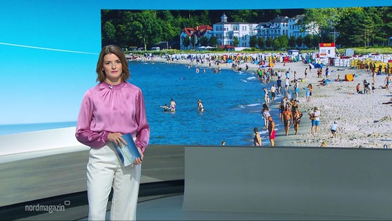 Nachrichtensprecherin Frauke Rauner, im Hintergrund ein Bild von einem Ostseestrand. © Screenshot 