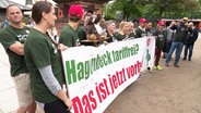 Streikende Mitarbeiter des Tierparks Hagenbeck halten ein Banner. © Screenshot 