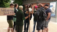 Mitarbeiter des Tierparks Hagenbeck mit Plakaten fordern einen Tarifvertrag. © Screenshot 