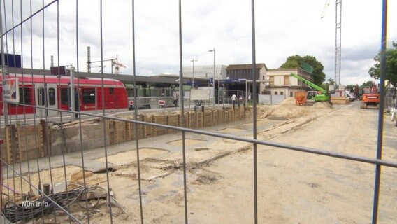 Blick durch ein Bauzaun auf eine Baustelle an einem Bahngleis. © Screenshot 