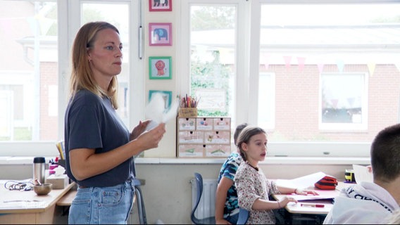 Eine Lehrerin unterrichtet Grundschüler. © Screenshot 