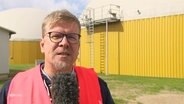Reporter David Pilgrim berichtet live vom Außengelände der Bio-LNG-Anlage. © Screenshot 