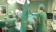 Klinikpersonal während einer OP in einem OP-Saal eines Krankenhauses. © Screenshot 