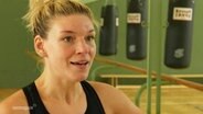 Weltmeisterin Nina Meinke im Interview in einer Sporthalle, im Hintergrund hängt ein Boxsack. © Screenshot 
