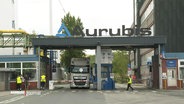 Die Firma Aurubis von Außen. Lkw stehen vor einer Schranke. © Screenshot 
