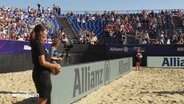 Zwei junge Frauen stehen am Rande eines Beachvolleyball-Feldes. © Screenshot 