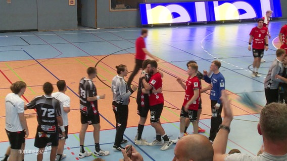Zwei Handball-Mannschaften klatschen sich ab. © Screenshot 