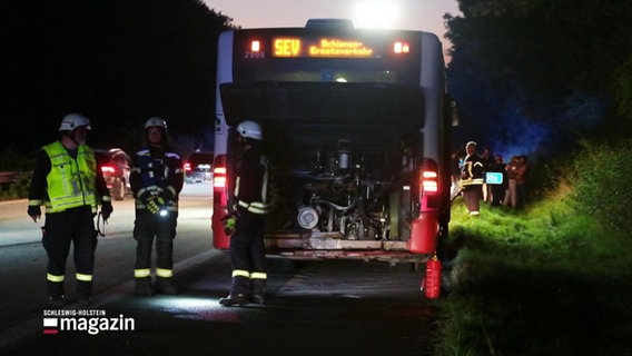 Rettungskräfte stehen hinter einem Bus, deren Motroraum geöffnet ist. © Screenshot 