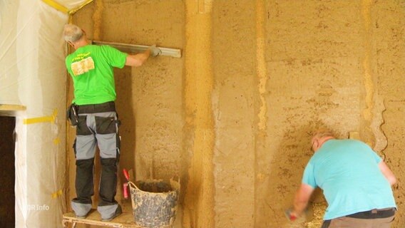 Lehmbauer verputzen eine Wand. © Screenshot 