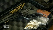 Eine Waffe und Patronen liegen in einem geöffneten Waffenkoffer. © Screenshot 