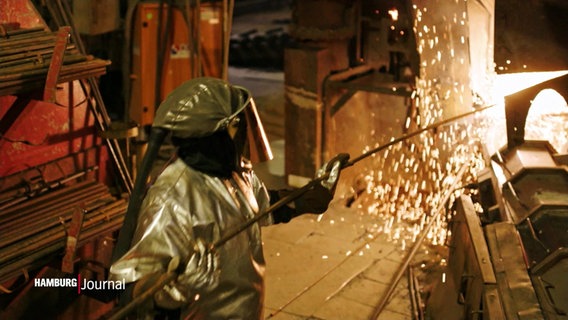 Ein Metallarbeiter steht in einer Industrieanlage. © Screenshot 