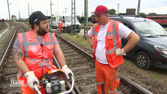 Ein Reporter im Gespräch mit einem Gleisarbeiter. © Screenshot 