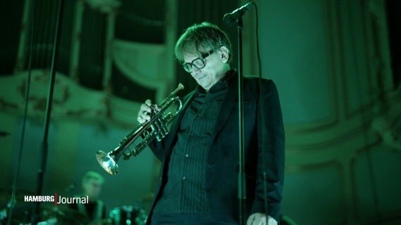 Ein Mann mit einer Trompete in der Hand steht auf einer Bühne. © Screenshot 